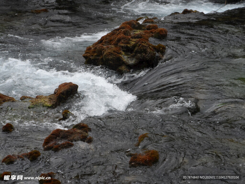 湍急溪流中的褐色岩石