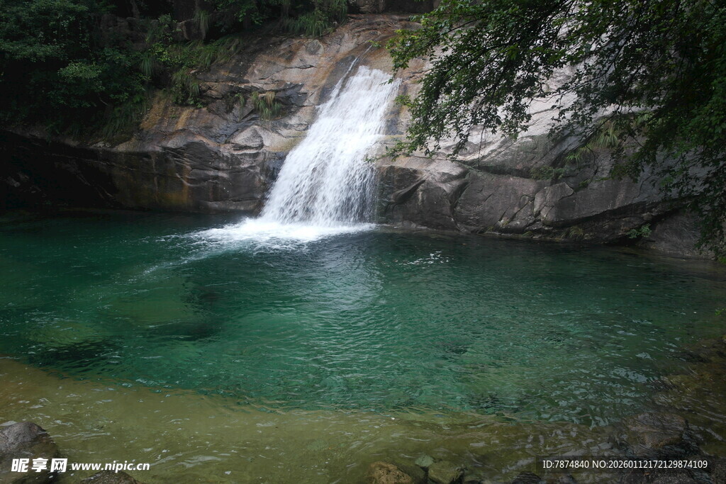 山间清澈瀑布下的碧绿潭水