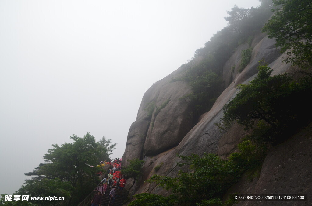 雾中攀岩者勇攀陡峭岩壁