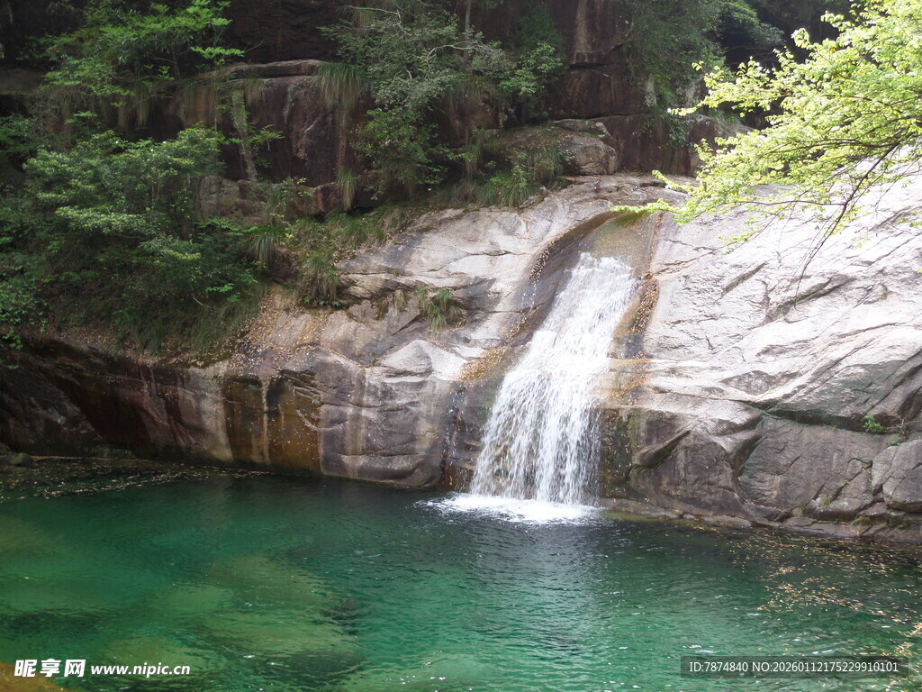 山间清澈瀑布下的碧绿潭水