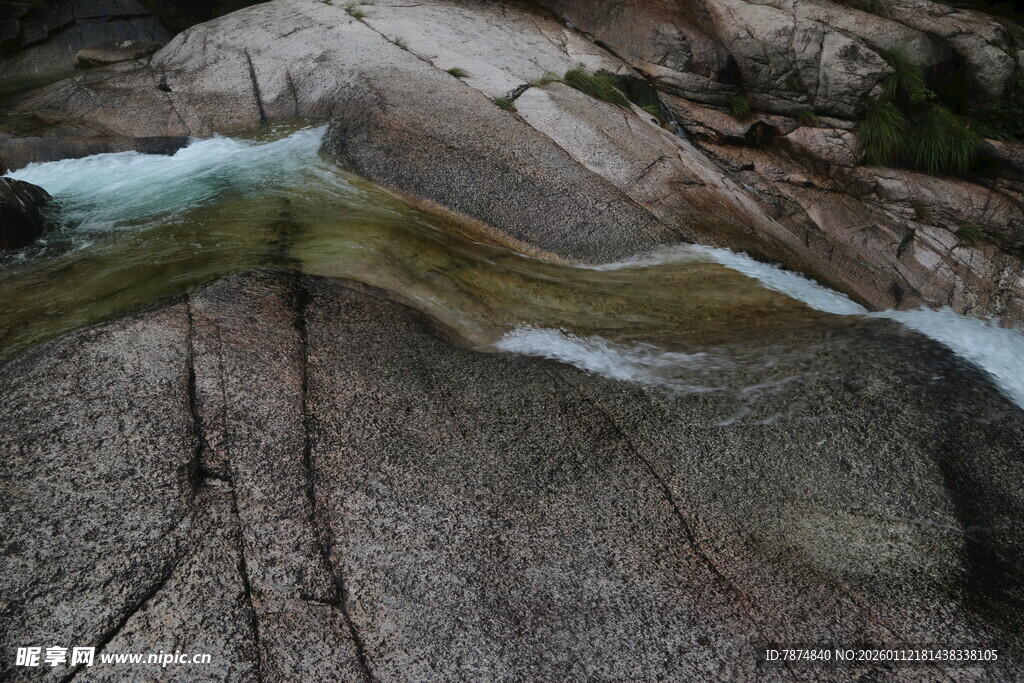 山间石上流淌的清澈溪流