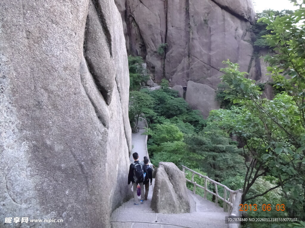 游客攀登陡峭石壁景观