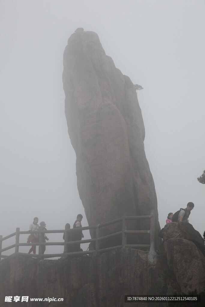 雾中奇石旁的游客身影