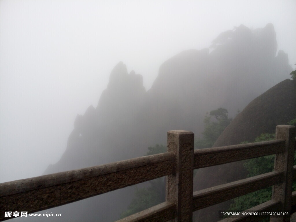 雾中峻岭旁的木质护栏
