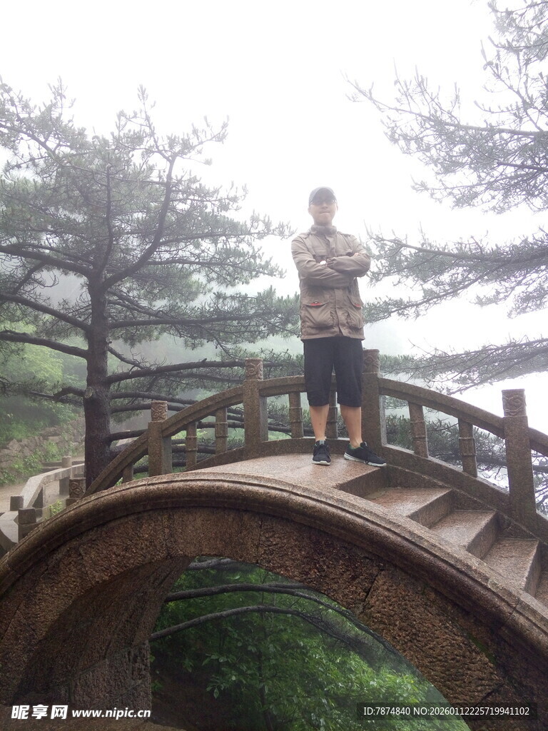 男子立于山间古桥之上