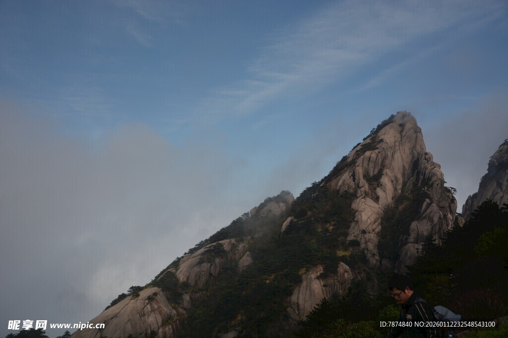 巍峨山峰耸立于蓝天白云间