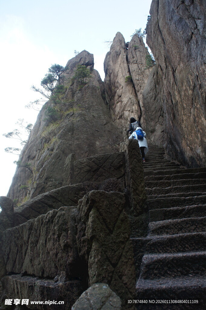 攀登陡峭山间石阶的旅人
