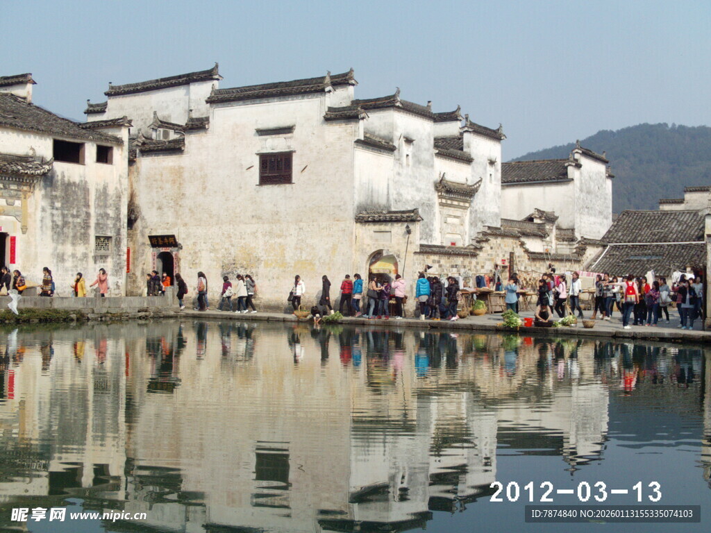 水乡古建旁的人群倒影风光