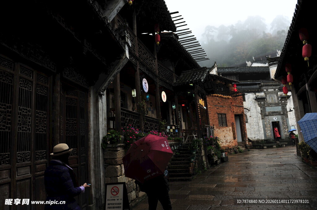 烟雨古巷中的撑伞行人