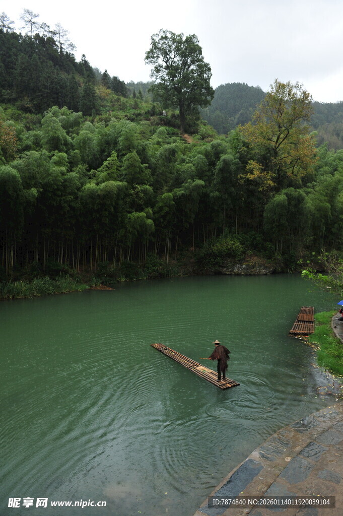 山间碧潭中竹筏上的旅人