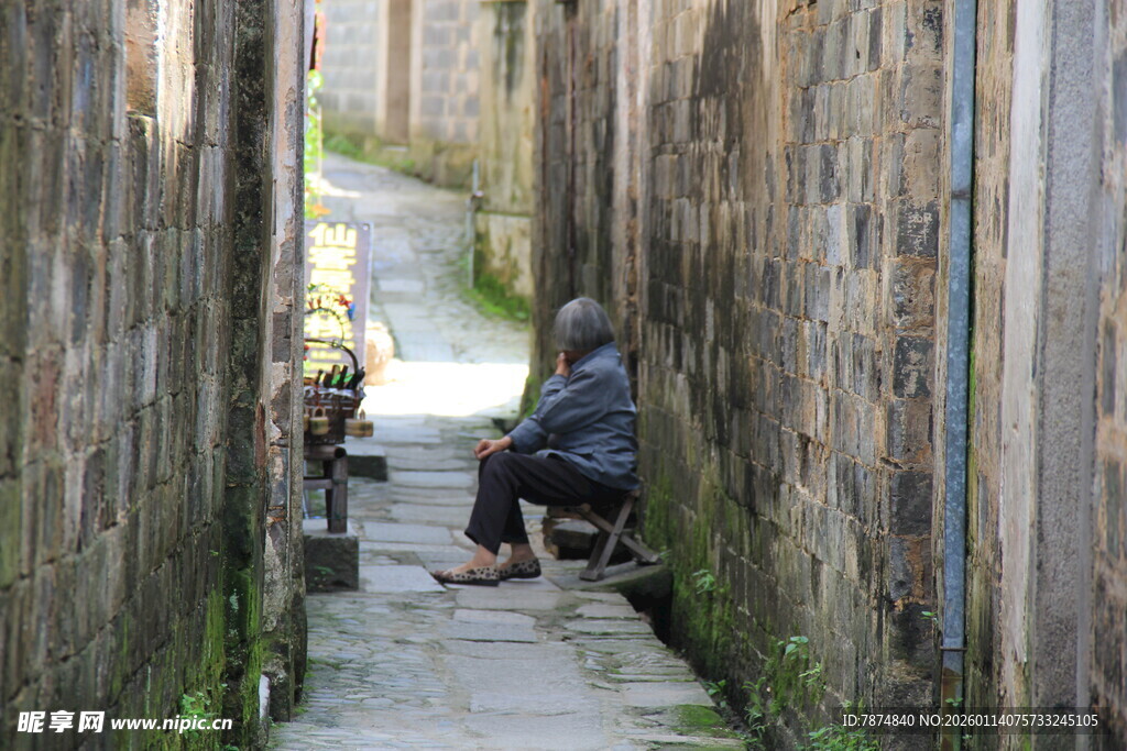 狭窄小巷中独坐的身影