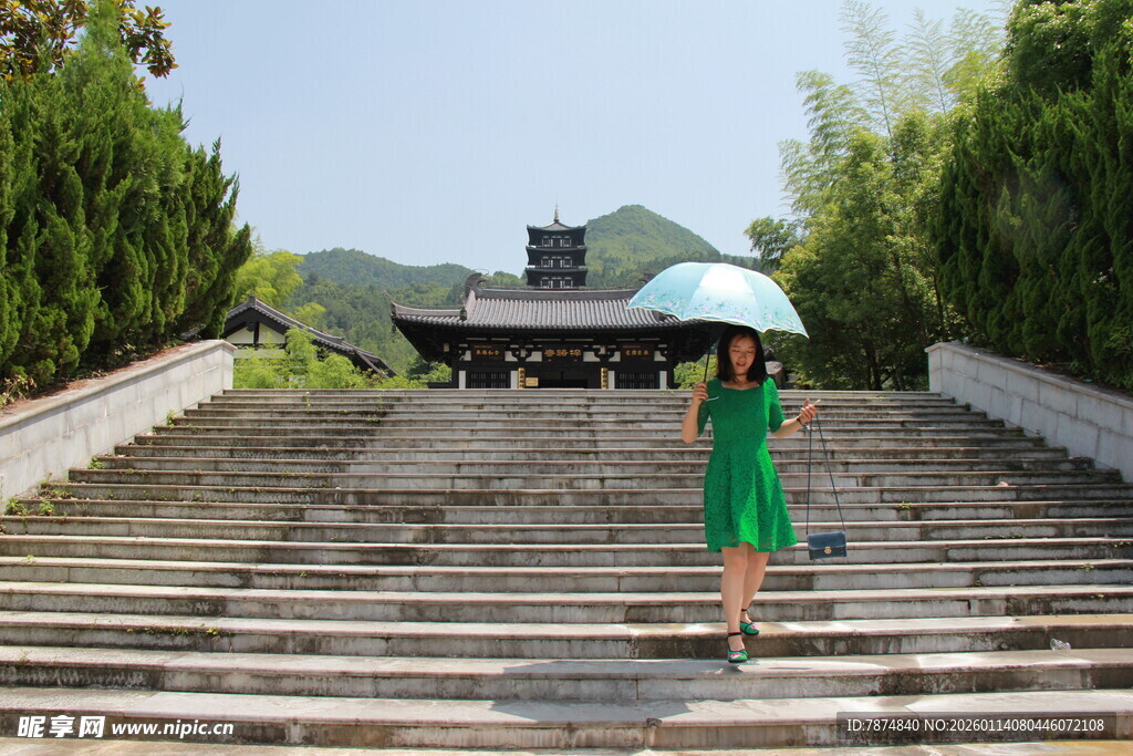 绿衣女子漫步石阶美景处