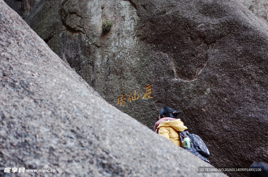 攀岩者于巨石间奋力攀爬