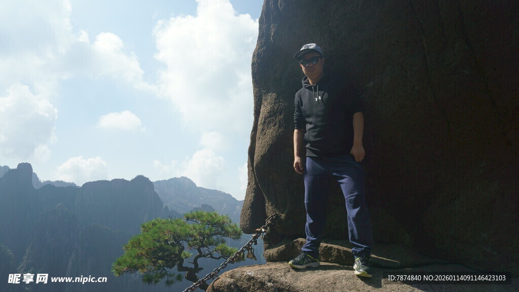 男子立于山巅岩石处