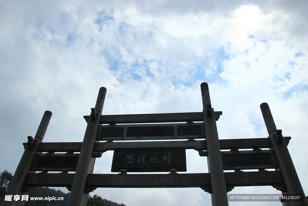 古朴牌坊立于蓝天白云下