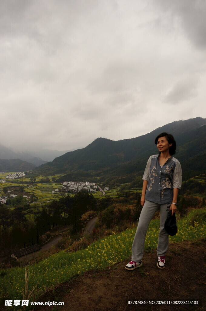 女子于山间田野处留影