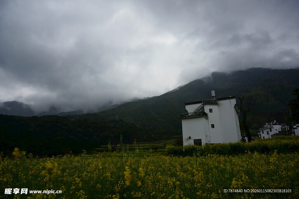 田野中的白屋与远山云雾