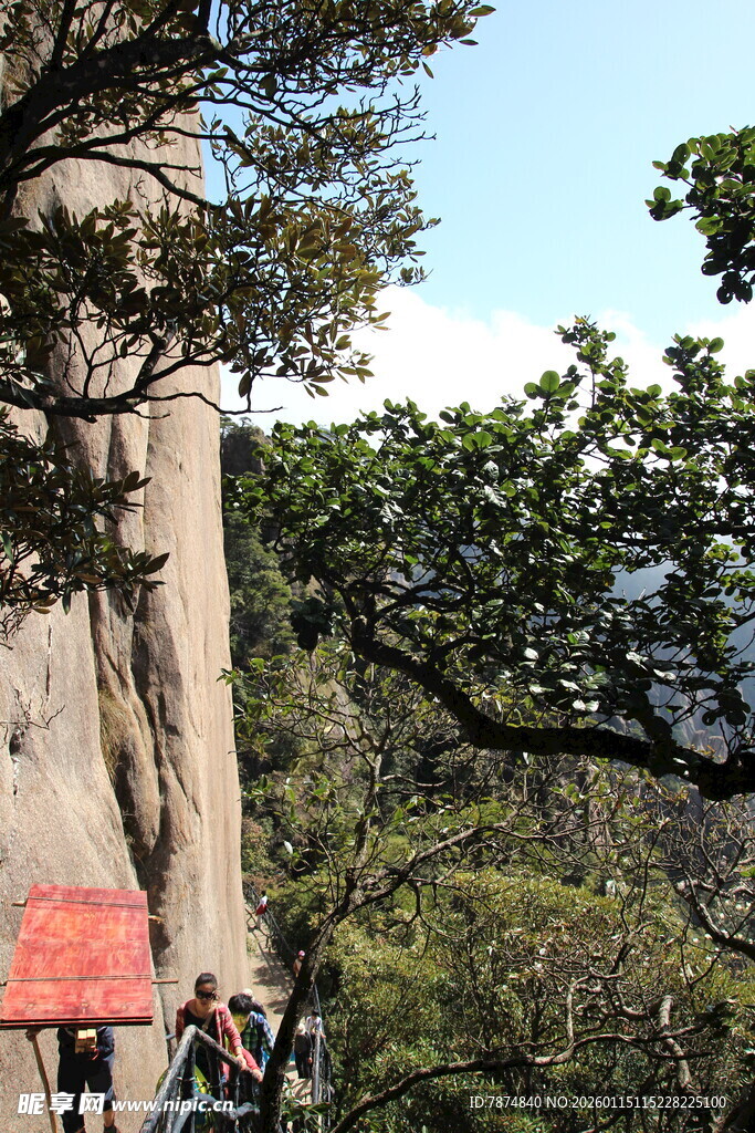 游客攀登陡峭山峰