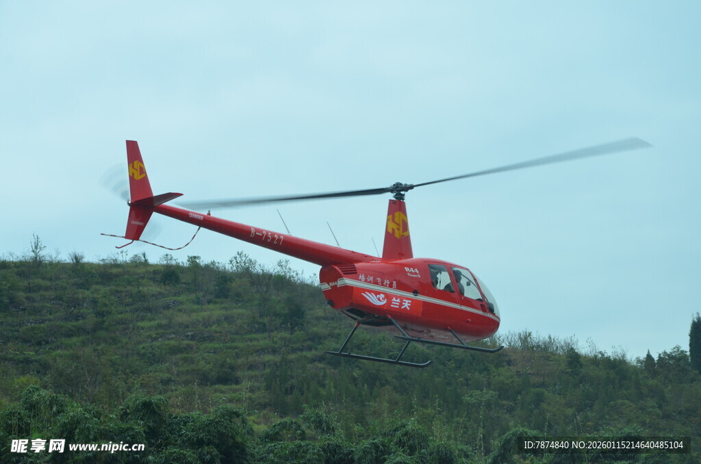 红色直升机翱翔于青山之上