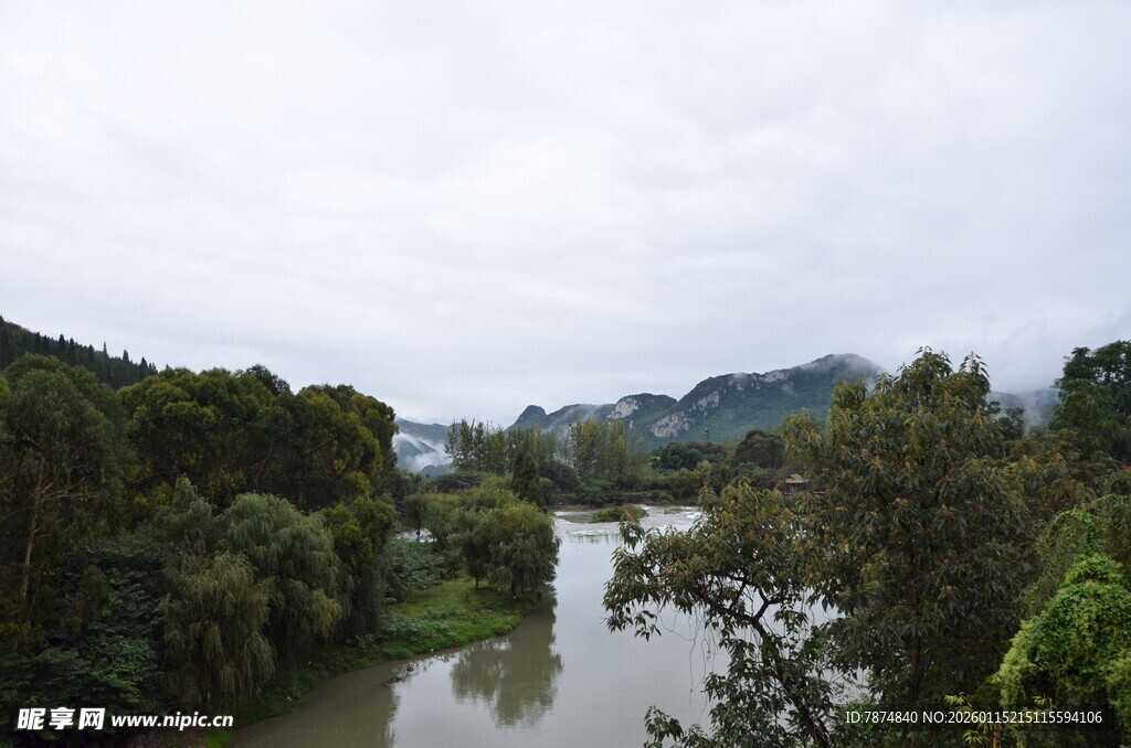 河畔葱郁山林风景图
