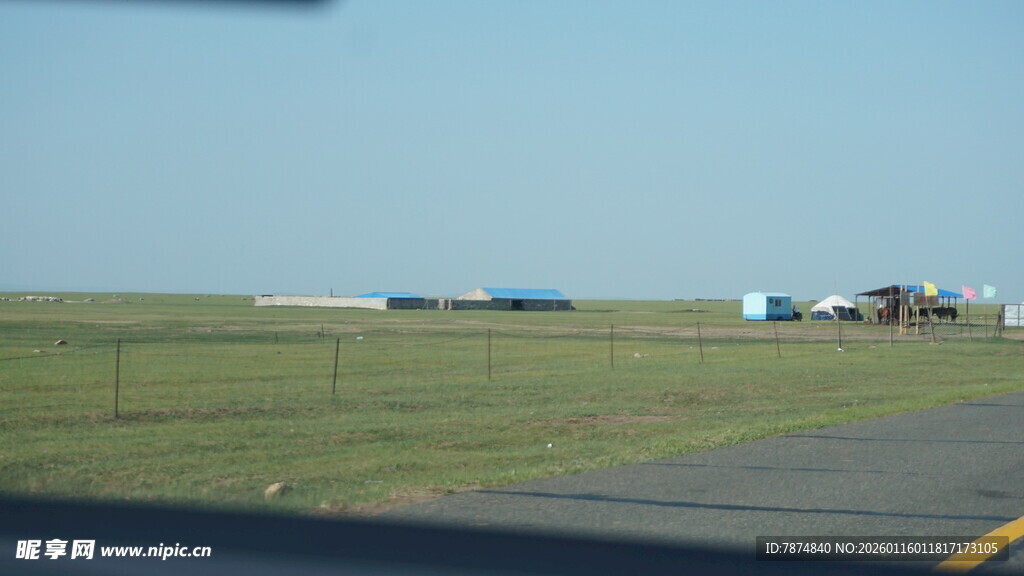 公路旁开阔草地与远处建筑