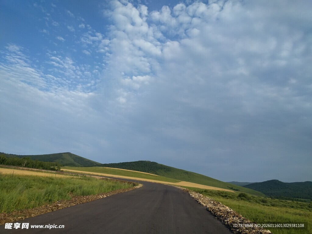 蜿蜒公路穿行于绿野蓝天