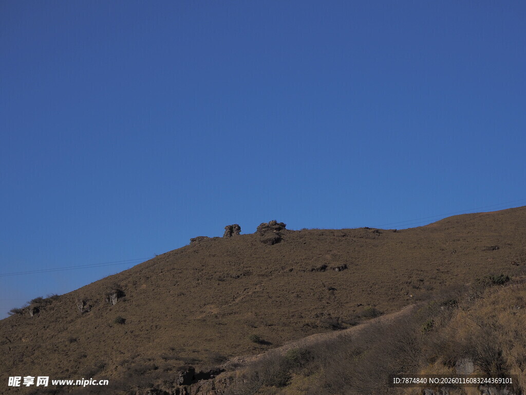 蓝天映衬下的褐色山丘
