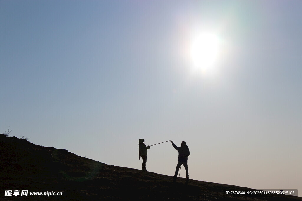 阳光下两人的山顶剪影