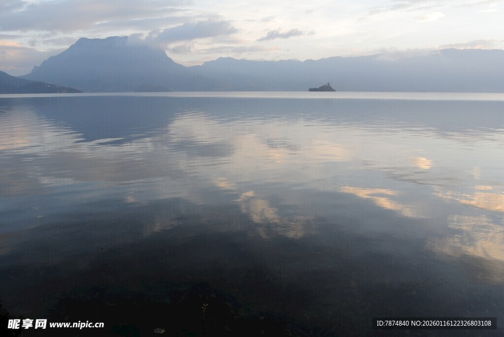 平静湖面倒映天空与远山