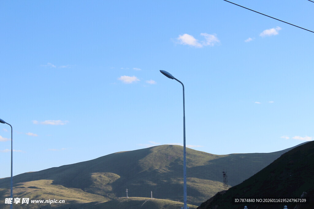 蓝天山丘间的路灯景观
