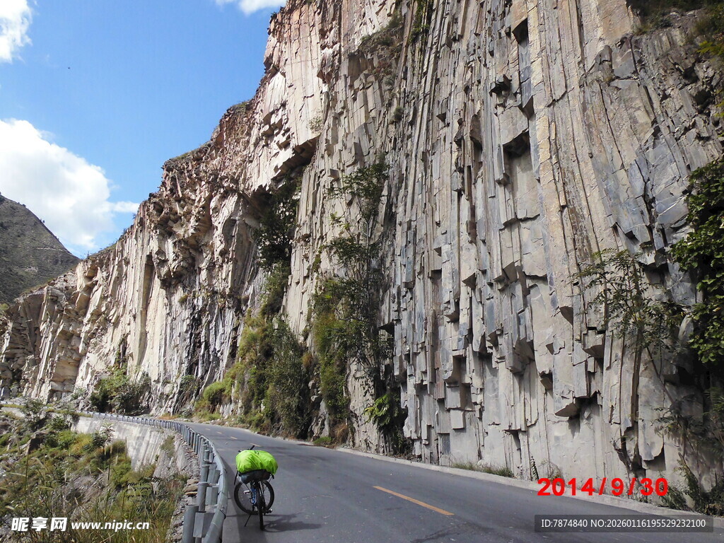 骑行者穿行于险峻山间公路