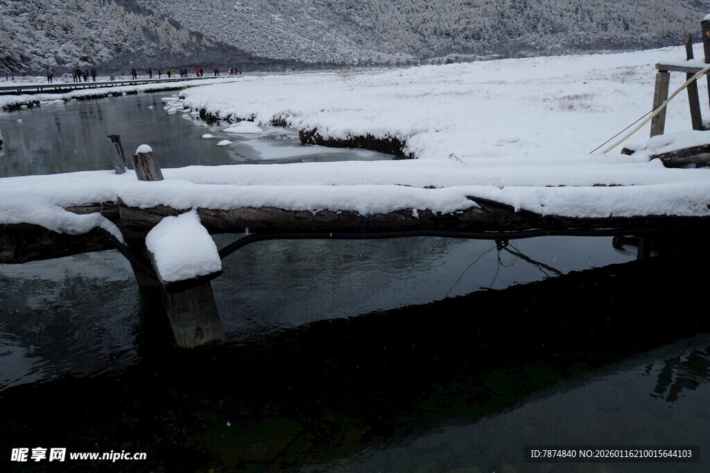 冬日河畔覆雪的横卧木材