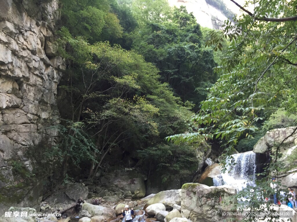 山间瀑布下的休闲人群