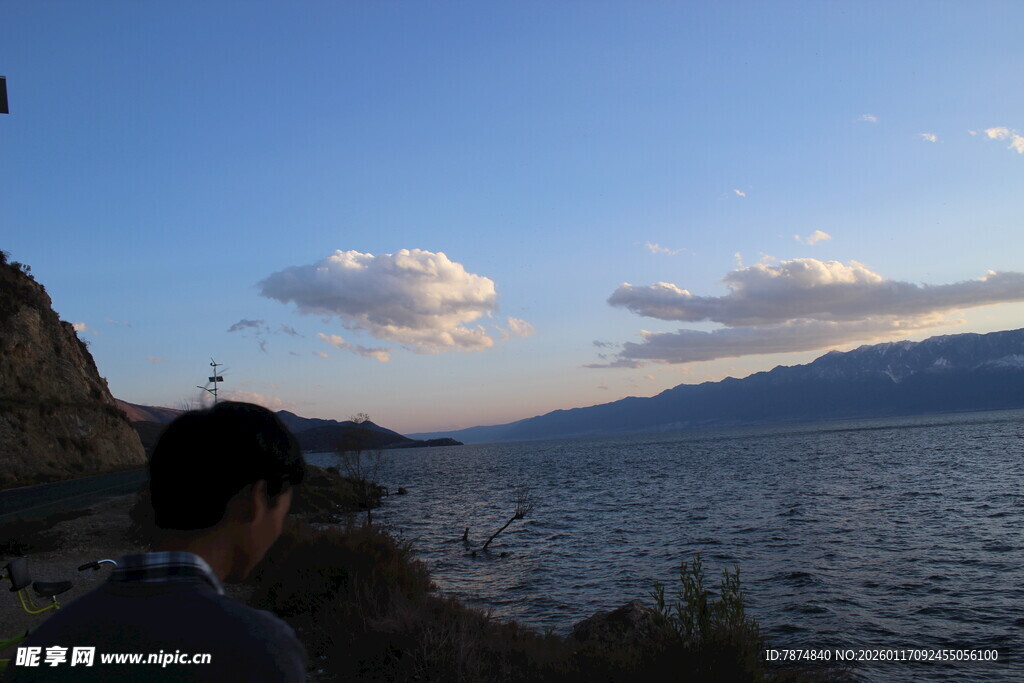 男子赏景于湖畔黄昏时