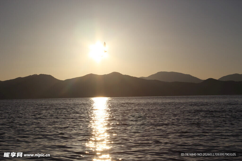 夕阳下的宁静海面与远山