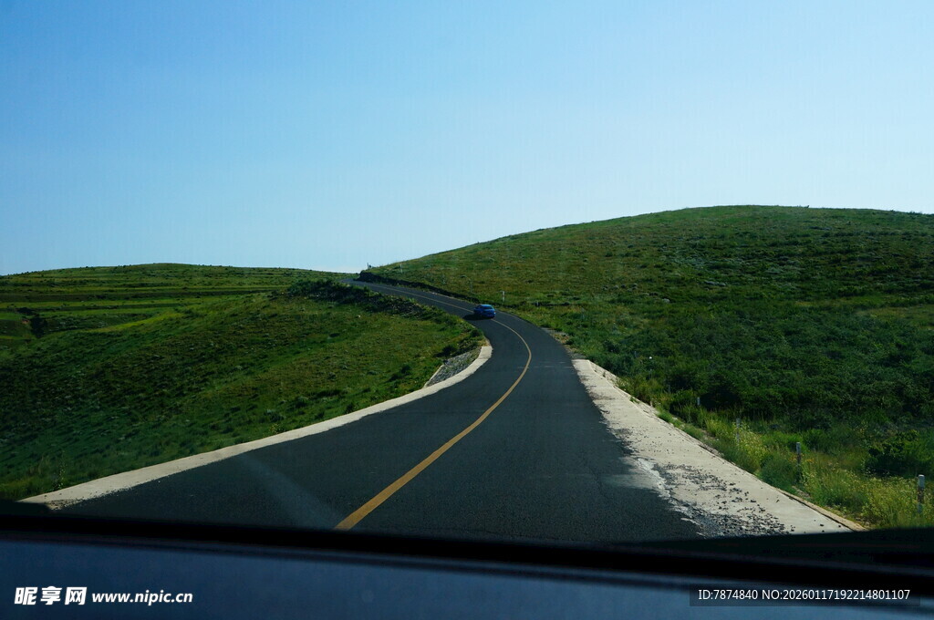 公路蜿蜒于翠绿山丘间