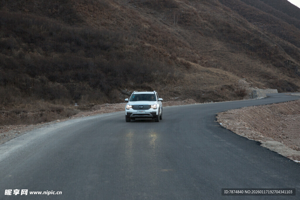 山间公路上行驶的白色汽车