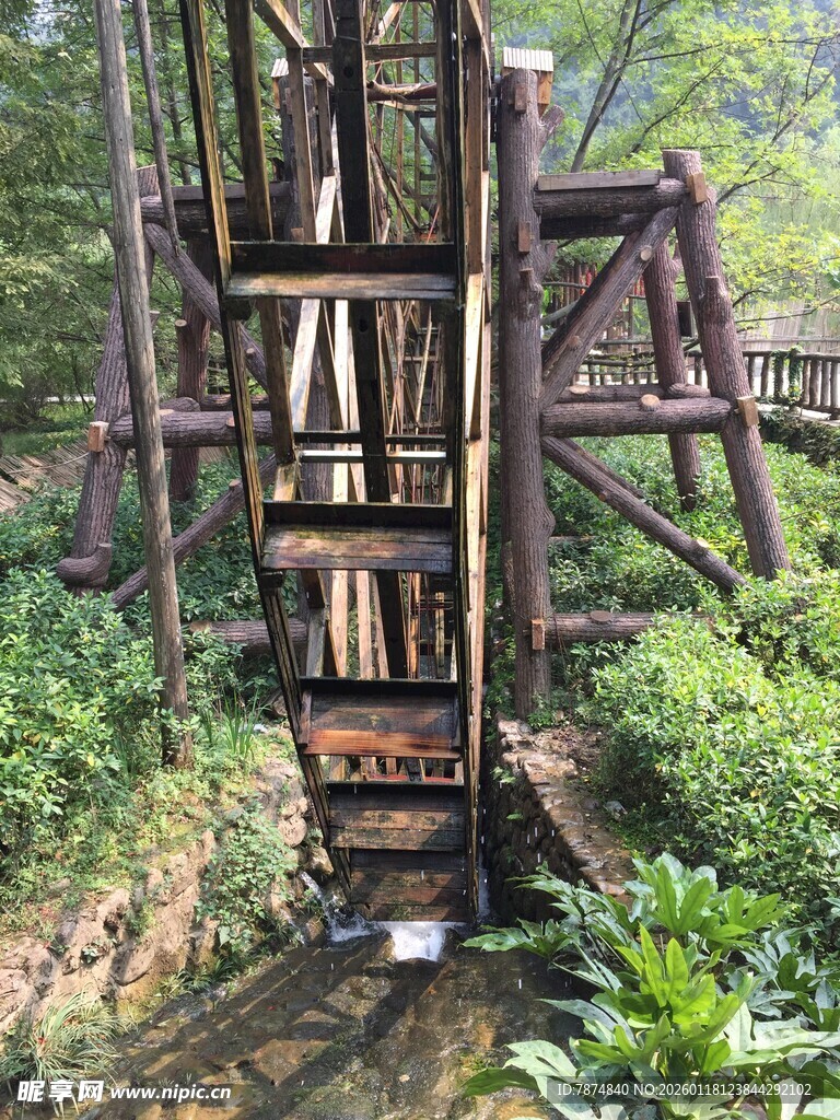 古老木质水车立于绿意中