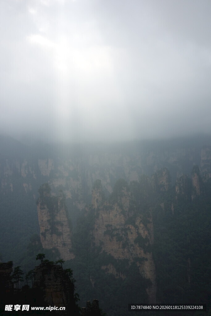阳光穿透雾霭下的山峦