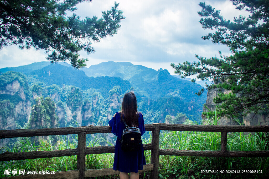 女子赏景于山间木栏旁