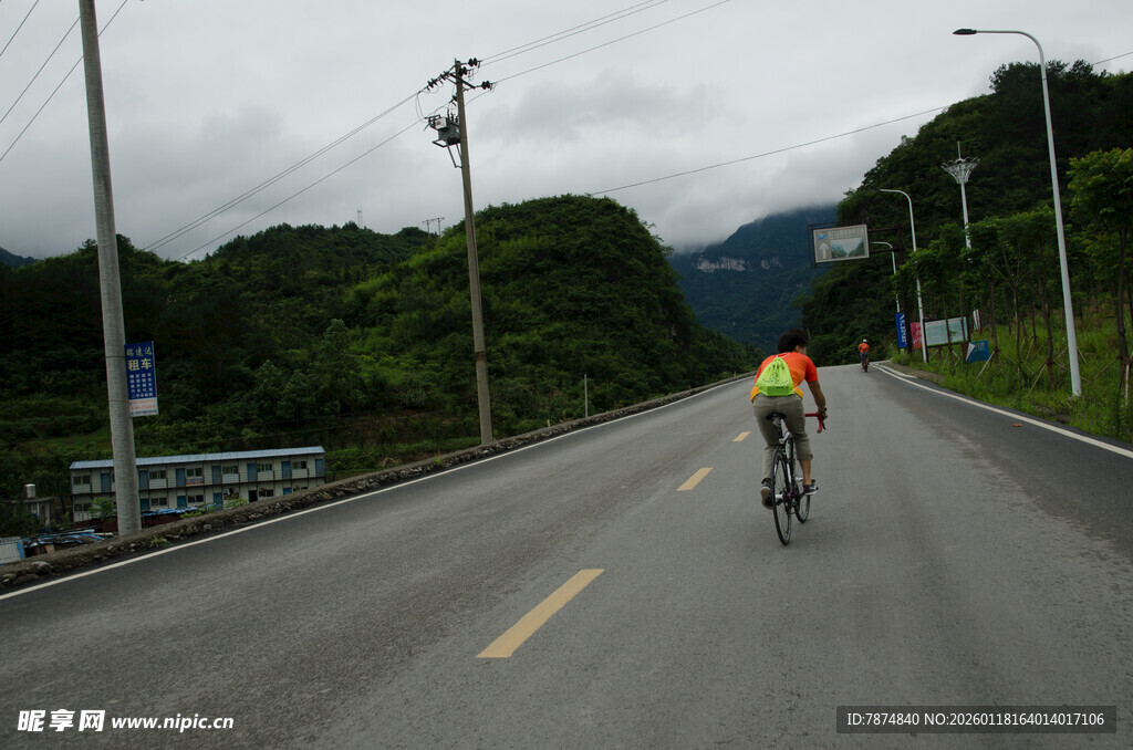 公路骑行者穿行青山间
