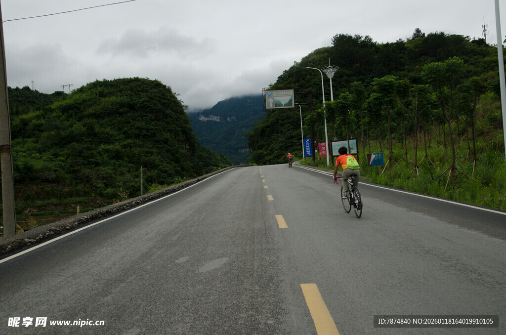 公路骑行者穿行青山间