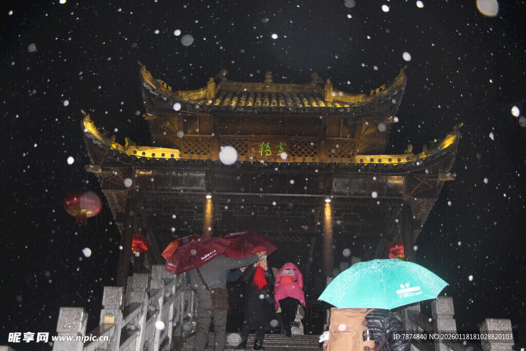 雪夜古牌坊下的撑伞行人