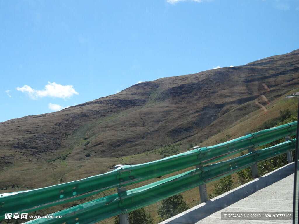 公路旁的绿色护栏与远山
