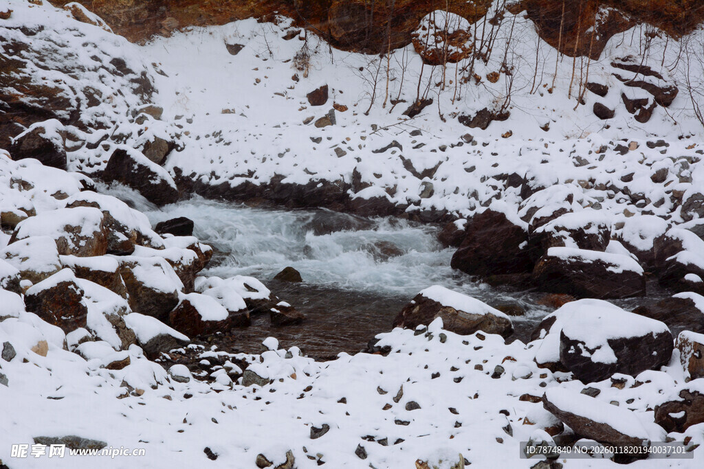 雪覆溪流间的嶙峋岩石