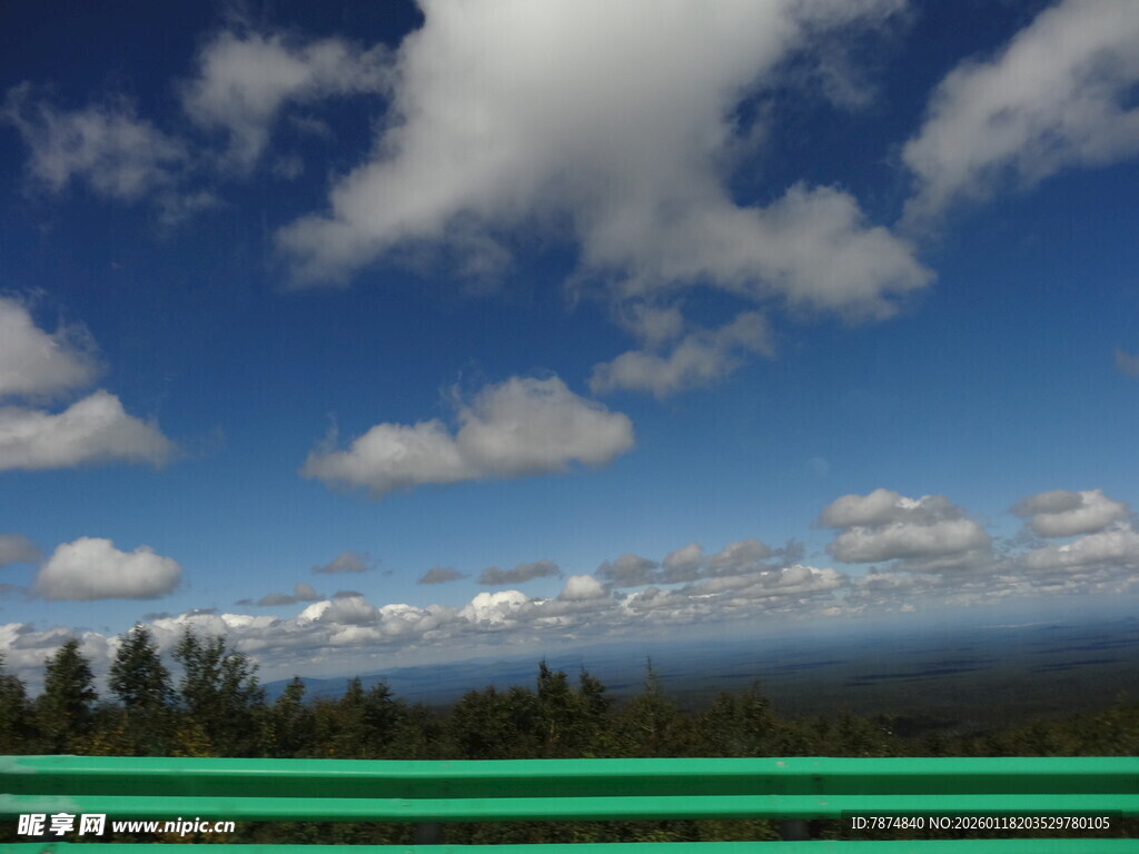 蓝天白云下的开阔山林景色