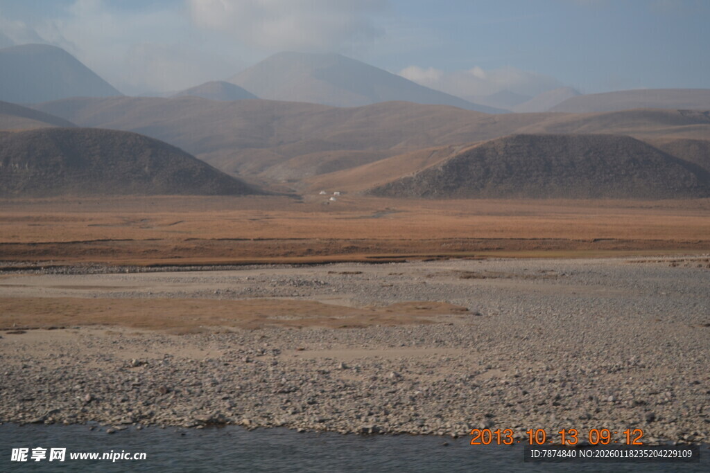 荒凉河谷与远处山峦景观