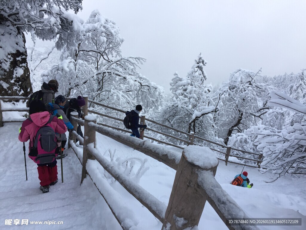 雪地徒步者沿木栏杆前行