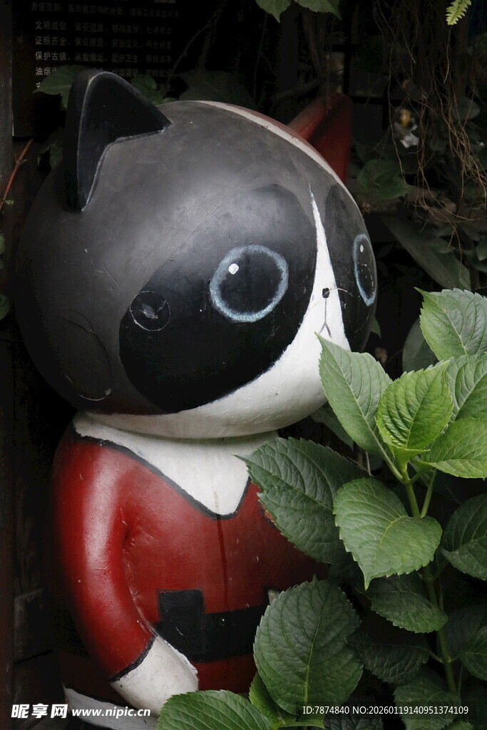 黑猫人偶置身绿植间