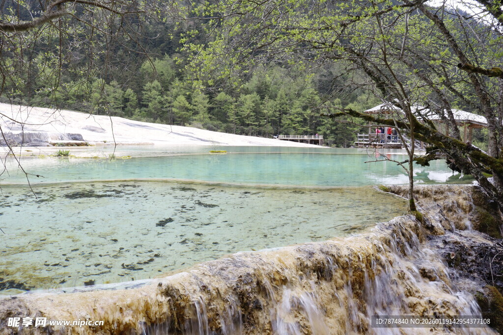 山间清澈瀑布下的碧绿湖水